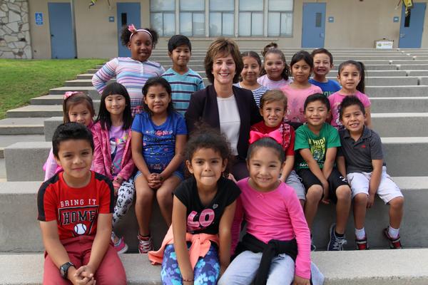 Superintendent Joanne Culverhouse surrounded by smiling students.